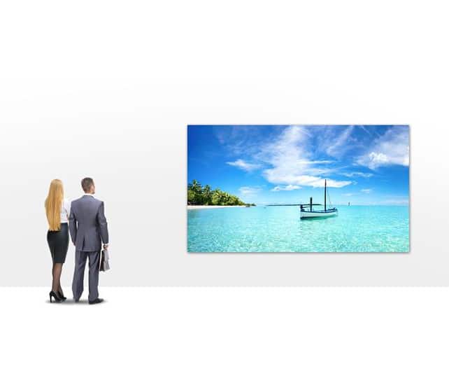 business people viewing wall art depicting beach scene